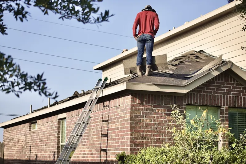 Professional roofer working on a residential roof in Coy